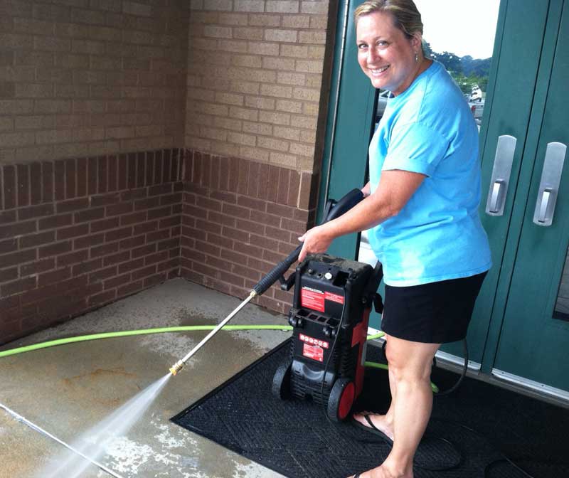 Lee Ellen Gaston wields a pressure washer doing her part to clean up the community. Photo/Special.