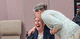 Sallie Satterthwaite (seated in wheelchair) receives a greeting from a friend at a reception in her honor Sept. 24, 2017, at Christ Our Shepherd Lutheran Church in Peachtree City. Photo/Cal Beverly.