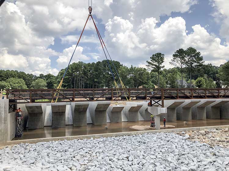 Massive bridge span now sits atop Lake Peachtree...