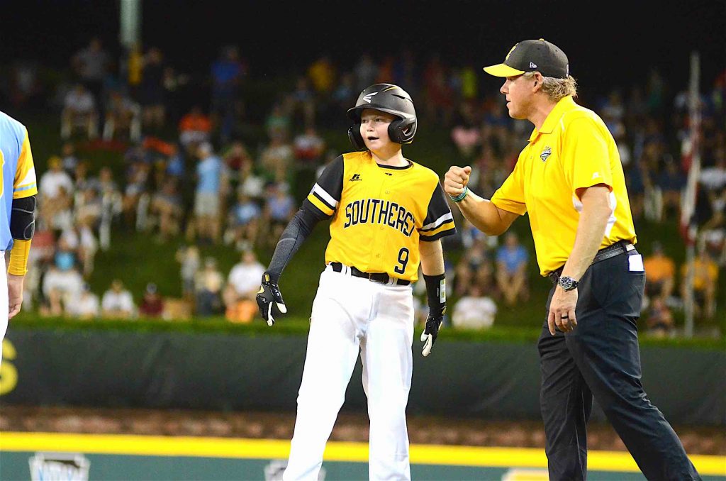 Peachtree City Little League’s Chase Fralick talks with his coach after connecting with a single during the second day of the Little League World Series. Photo/Brett R. Crossley.