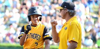 Peachtree City’s Tai Peete gives his coach a pound after hitting the second of two singles against Honolulu. Photo/Brett R. Crossley.