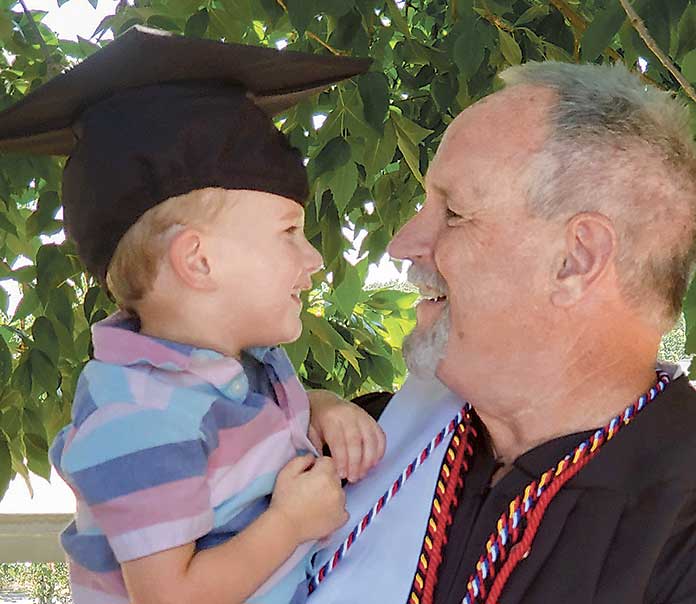 Two-and-a-half-year-old Kayden Pye celebrates with his grandfather, Assistant Police Chief Stan Pye, at Georgia Military College Commencement Ceremonies June 1. Photo/Submitted.