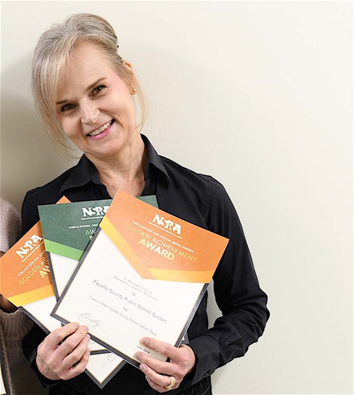 Melinda Berry-Dreisbach, public information officer, proudly displays the awards she received from the National School Public Relations Association.