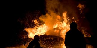 Shutterstock photo of firefighters at vehicle blaze.