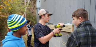 The Foundry High School students working at the home of Fayetteville Vietnam veteran MacArthur Starr as a way to honor him included, from left, Najeh Hanif, Jackson Mayer and Tanner Tatum; with Reese Wackes in the rear. Photo/Submitted.