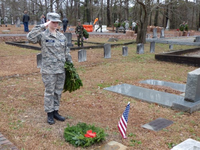 Civil Air Patrol Cadet and Peachtree City resident Skyla Ziegler salutes after placing a wreath at the gravesite of a veteran in the Fayetteville Cemetery at the Wreaths across America observance on Dec. 14. Photo/Ben Nelms.