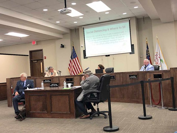 Properly separated for social distancing rules, the five members of the Peachtree City Council get ready to hear the first agenda item at the May 21 meeting at City Hall. Photo/Cal Beverly.