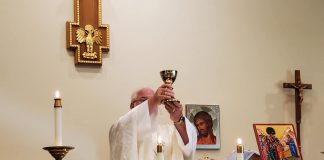 Rector David Epps prepares Communion. Photo/Submitted.