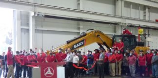 The manufacturing team at SANY America in Peachtree City was recognized June 24 for their efforts in completing the company's 100th SY215C excavator. The team is assembled in front of the large machine. Photo/Ben Nelms.