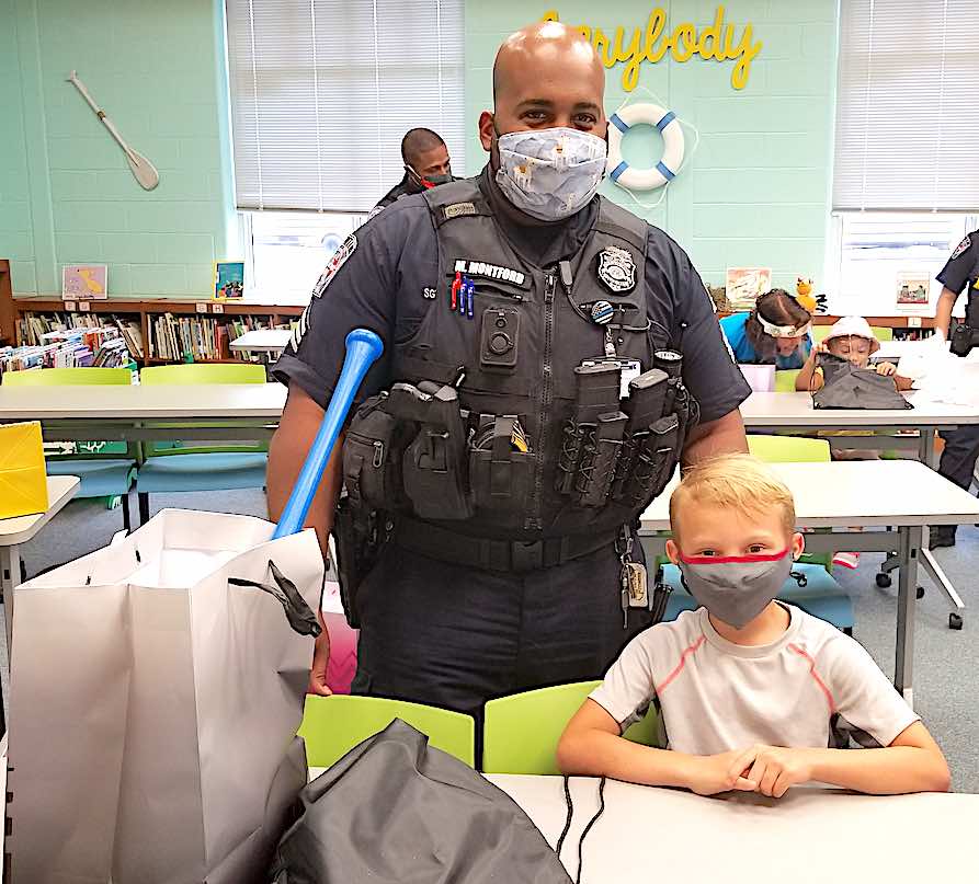 <b>Fayetteville police officers representing their department’s CARE unit presented first grader Caleb Eden with a baseball bat and related equipment for extraordinarily demonstrating the school’s expectations of a Cleveland Crocodile.</b>