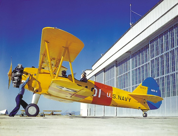 A U.S. sailor cranking the engine of a Stearman N2S-2 Kaydet (BuNo 3553) at the Naval Air Station Corpus Christi, Texas (USA), in 1943.