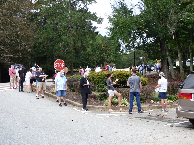 <b>Voting lines for the first day of early voting on Oct. 12 at the Peachtree City Library stretched into the parking lot and onto Willowbend Road. Photo/Ben Nelms.</b>