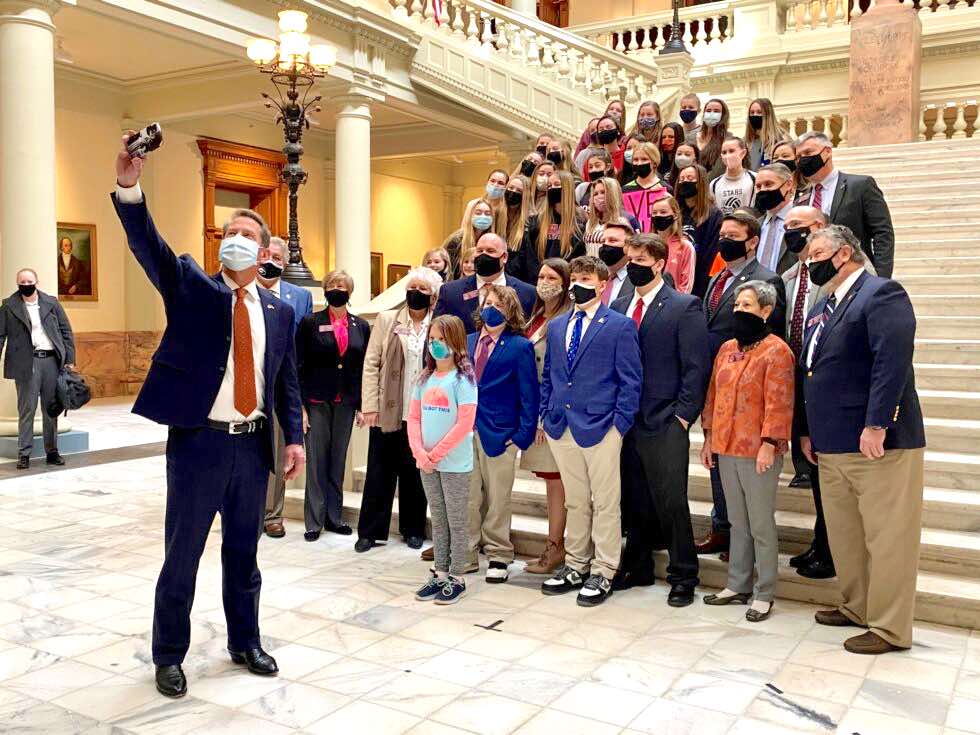 <b>Gov. Brian Kemp (left) takes a selfie with student athletes after a news conference to support legislation banning transgender participation in Georgia girls’ sports on Feb. 4, 2021. Photo/Beau Evans of Capitol Beat News Service.</b>