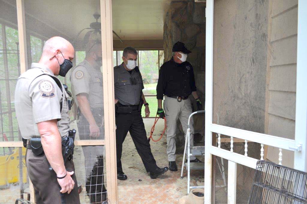 <b>Inside the animal-filled residence are (L-R), Jerry Collins, director of the Fayette County Animal Shelter (in black shirt), Chief Harold Myers of the Fayette County Marshals office and two deputies from the Fayette County Sheriff’s Office. Photo/Submitted.</b>