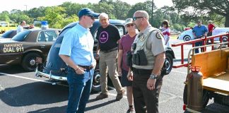 Pastor Josh Saefkow (L, with blue baseball cap) talks with Fayette County Sheriff Barry Babb during the church's car and craft show in June 2023 at the church on Flat Creek Trail. Photo/Roger Alford.