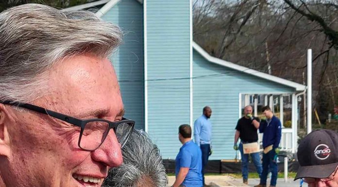 Ms. Derryl Anderson (with Rick Halbert) looks on as her new home receives finishing touches. Photo/City of Fayetteville, Ga.