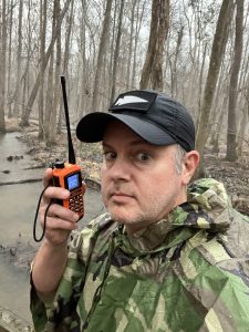 The author (FCC license: KI4ASK) using a waterproof, handheld VHF ham radio during inclement weather. Photo/Joe Domaleski