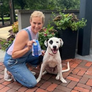 Mary Catherine Domaleski holding the American Kennel Club certification ribbons earned by Loki the therapy dog. Photo/Joe Domaleski