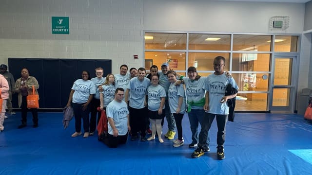 Participants in matching T-shirts pose together at the Summit Family YMCA.