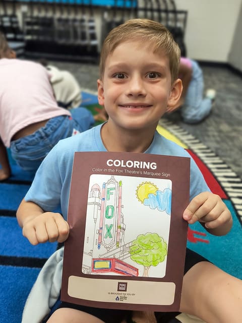 Inman Elementary student holding a colored Fox Theatre marquee page