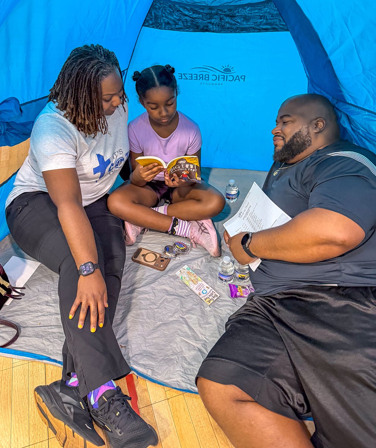 A family reads together in a tent at Camp Read-A-Lot