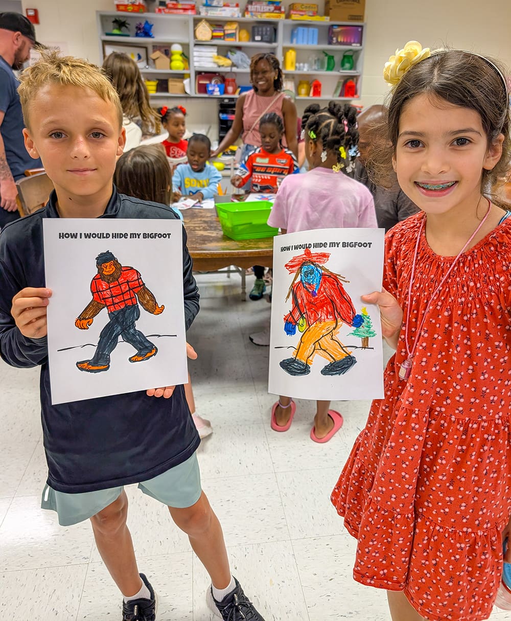Two students show their Big Foot drawings