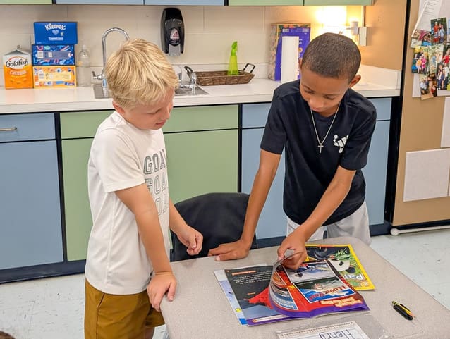 Two Braelinn students look at a book together