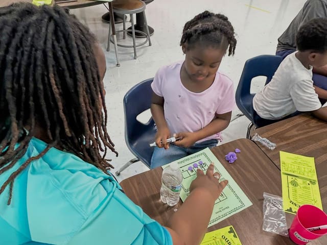 Families read together at a Literacy Cafe workshop table